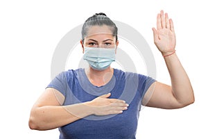Woman making honest oath gesture wearing disposable covid19 mask