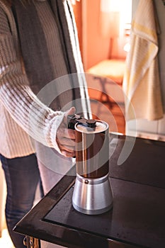 Woman making hot coffee drink with percolator