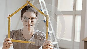 Woman making a house shape with a folding ruler