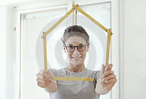 Woman making a house shape with a folding ruler