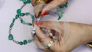 A woman making jewelry with Colombian emeralds