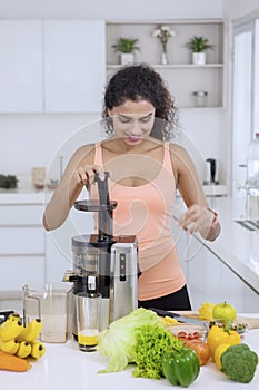 Woman making juice from vegetables and fruits