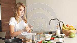 Woman making kebabs from meat and vegetable on chopping board in kitchen.