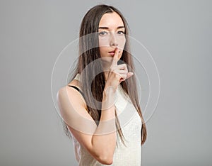 Woman making keep it quiet gesture