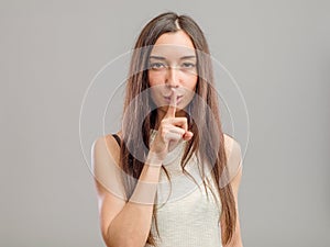 Woman making keep it quiet gesture