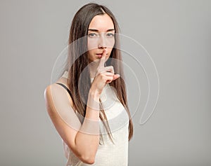 Woman making keep it quiet gesture