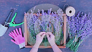 Woman Making Lavender Bouquet. SLOW MOTION. Unrecognizable female florist hands creating decoration with purpule