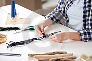 woman making macrame and knotting cords