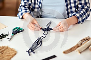 woman making macrame and knotting cords