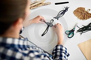 woman making macrame and knotting cords