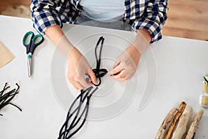 woman making macrame and knotting cords