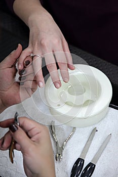 Woman making manicure using nailfile with nail care tools background photo