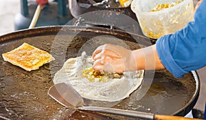 A woman making Muslim food called Mataba