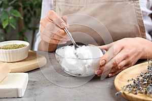 Woman making natural handmade soap at stone table, closeup