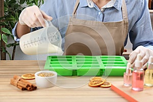 Woman making natural handmade soap at table, closeup