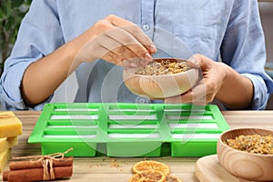 Woman making natural handmade soap at table, closeup