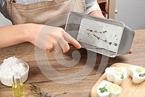 Woman making natural handmade soap at table, closeup