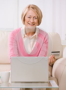 Woman making online purchase on laptop wit