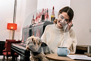 Woman making a phone call while sitting in a cafe