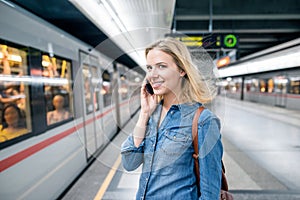 Woman making phone call at the underground platform, waiting