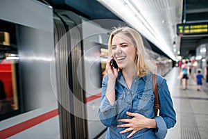 Woman making phone call at the underground platform, waiting