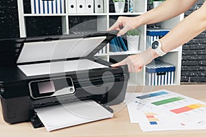 Woman making photocopy using copier in office