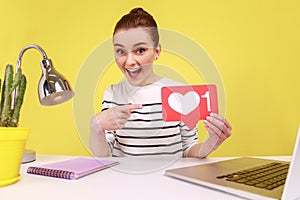 Woman making point of view photo while sits at workplace broadcasting livestream showing like icon.