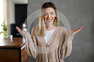 Woman making scale with her arms wide open. Smiling woman does not know which is the right decision