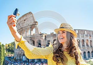 Woman making selfie in front of colosseum in rome