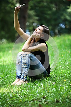 Woman making selfie and relaxing outdoors looking happy and smiling