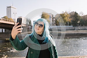 Woman making selfie while standing side river