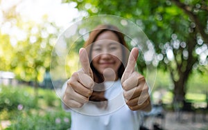 A woman making and showing thumbs up hand sign