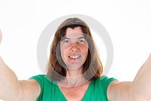 Woman making smartphone selfie with cellphone over isolated white background middle aged portrait