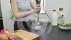 Woman is making the smoothie with milk in blender