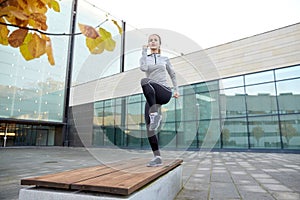 Woman making step exercise on city street bench