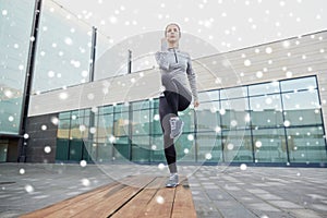 Woman making step exercise on city street bench