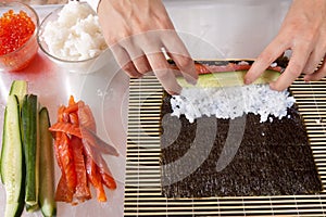 Woman making sushi rolls