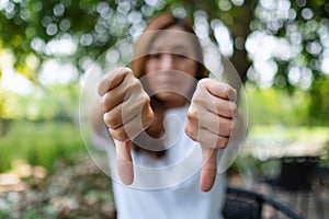 A woman making thumbs down hands sign