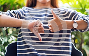 A woman making thumbs up and thumbs down hands sign