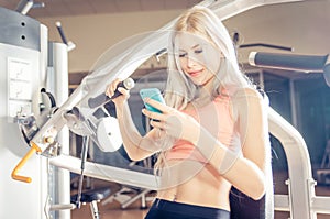Woman making training in the gym and checking her schedule on th