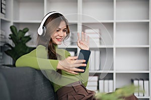 woman making video call on smartphone with family or friends happily