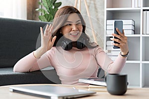 woman making video call on smartphone with family or friends happily