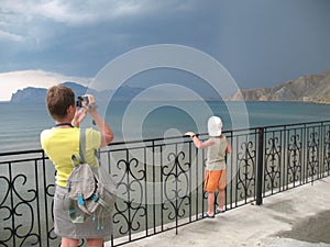 Woman making video of thunderstorm on sea