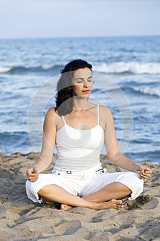 Woman making yoga on the beach