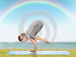 Woman making yoga in crane pose on mat