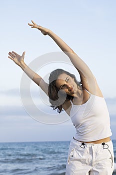 Woman making yoga exercise on the beach