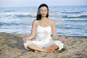 Woman making yoga exercise on the beach