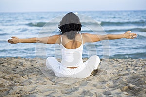 Woman making yoga exercise on the beach