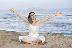 Woman making yoga exercise on the beach