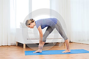 Woman making yoga intense stretch pose on mat